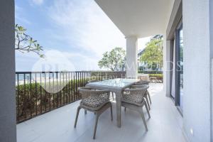 een tafel en stoelen op een balkon met uitzicht op de oceaan bij Bloomfields Executive 3BR Apt Fujairah Address in Fujairah