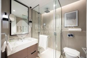 een badkamer met een glazen douche en een wastafel bij Bloomfields Executive 3BR Apt Fujairah Address in Fujairah