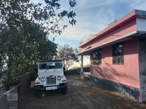 een witte jeep geparkeerd voor een huis bij Holidays Homestay Vagamon in Vagamon +7 foto's