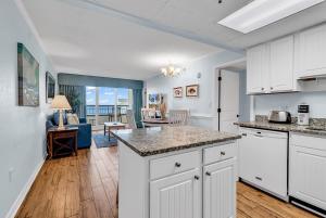 a kitchen with white cabinets and a living room at Oceanfront Luxury 2BR Litchfield Beach Escape in Pawleys Island +37 photos