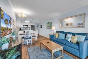 a living room with a blue couch and a table at Oceanfront Luxury 2BR Litchfield Beach Escape in Pawleys Island