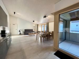 une cuisine et un salon avec une table et des chaises dans l'établissement Terrasse des vignes, à Cressier