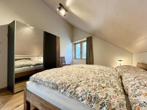 une chambre avec un lit et un grand miroir dans l'établissement Terrasse des vignes, à Cressier