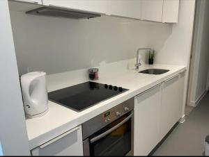 a white kitchen with a sink and a stove at Birmingham Central NewStreet 1Bed in Birmingham +7 photos