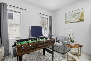 a living room with a foosball table and a couch at Sleeps 18! - 6 BR - 2 Kitchens in Jersey City