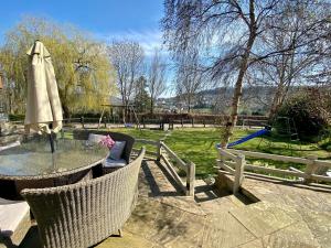 un patio con tavolo e sedie e un parco giochi di Coombehayes Barn a Uplyme Altre 20 foto