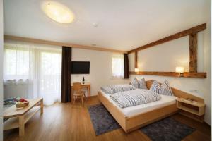 1 dormitorio con cama, mesa y TV en Hotel Residence Rabenstein, en Moso in Passiria