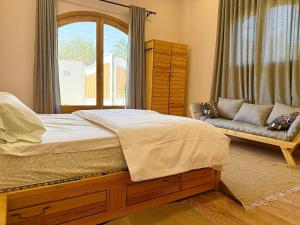 een slaapkamer met een bed, een raam en een bank bij Citadel Luxor in Luxor +106 foto's