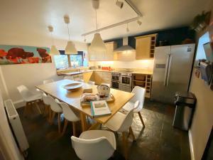 una cucina con un tavolo di legno e sedie bianche di Coombehayes Barn a Uplyme