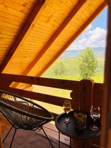 un tavolo e 2 bicchieri di vino sul balcone di Brvnara Duga njiva a Čelinac