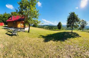 a small house with a red roof in a field at Brvnara Duga njiva Banjaluka in Čelinac