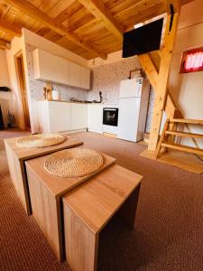 un soggiorno con 2 tavoli e una cucina di Brvnara Duga njiva a Čelinac Altre 8 foto