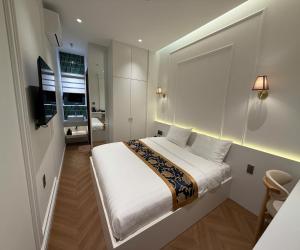 a bedroom with a large white bed in a room at Hoang Long Hotel in Mộ Ðức
