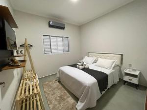 une chambre avec un lit avec un animal en peluche dessus dans l'établissement Casa Lago da Dinda 3, à Espirito Santo Do Pinhal