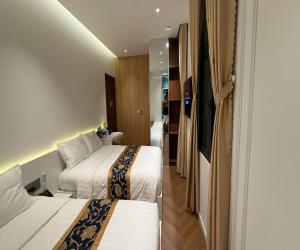 a hotel room with two beds and a couch at Hoang Long Hotel in Mộ Ðức