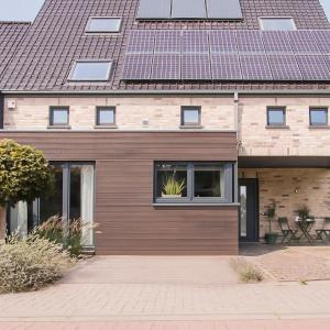 a house with a wooden facade with a roof at Green& Light House16 in Kettenis