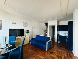 een woonkamer met een blauwe bank en een tafel bij Residence Villa Greta in Meina