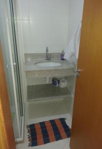a bathroom with a sink and a glass shower at Residencial Verano 105C in Guarajuba