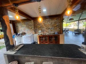 a dining room with a table and a stone wall at Chalé Gran Paraíso Cotijuba in Belém