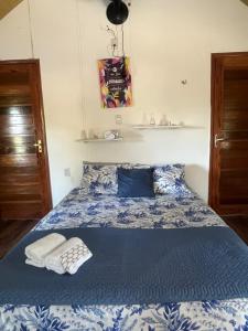 a bedroom with a blue and white bed with two towels at Chalé Gran Paraíso Cotijuba in Belém