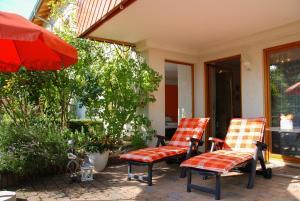 2 stoelen en een parasol op een patio bij Ferienwohnung Hameln Jasmin in Hameln