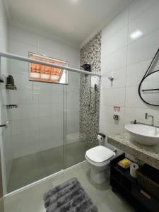 une salle de bains avec douche, toilettes et lavabo dans l'établissement Casa Lago da Dinda 3, à Espirito Santo Do Pinhal