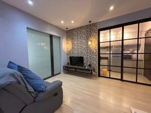una sala de estar con un sofá y un televisor en USJ One HomeStay by Jack, en Subang Jaya