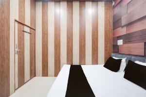 una camera da letto con un letto e una parete di legno di SPOT ON The Yeble Hotel And Restaurant a Etāwah