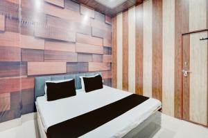 una camera da letto con un letto con una parete in legno di SPOT ON The Yeble Hotel And Restaurant a Etāwah