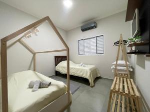 une petite chambre avec un lit et un miroir dans l'établissement Casa Lago da Dinda 3, à Espirito Santo Do Pinhal