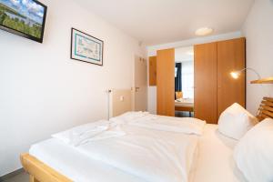 ein Schlafzimmer mit einem weißen Bett in einem Zimmer in der Unterkunft Ferienwohnungen Regina Maris in Bansin