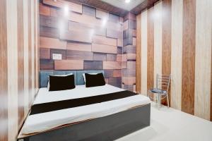 una camera da letto con un letto e una parete di legno di SPOT ON The Yeble Hotel And Restaurant a Etāwah
