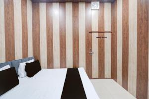 una camera da letto con un letto e una parete di legno di SPOT ON The Yeble Hotel And Restaurant a Etāwah