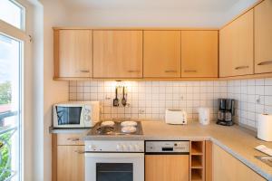 eine Küche mit Herd oberer Backofen neben einer Mikrowelle in der Unterkunft Ferienwohnungen Regina Maris in Bansin + 12 Fotos