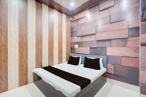 una camera da letto con un letto con una parete in legno di SPOT ON The Yeble Hotel And Restaurant a Etāwah Altre 23 foto