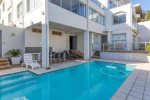 a swimming pool in front of a building at Luxury Camps Bay Getaway in Cape Town