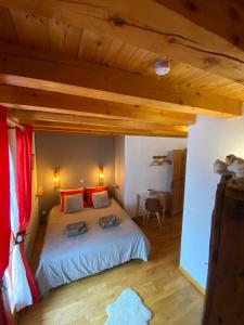 een slaapkamer met een groot bed met rode kussens bij La Roche Meane in Villar-dʼArène