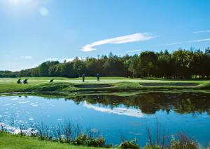 a view of a golf course with a pond at Eden Lodge Retreat in Crosby +101 photos