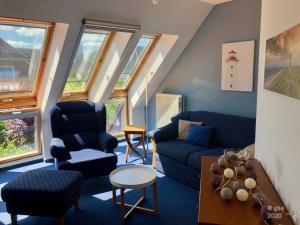 ein Wohnzimmer mit blauen Möbeln und Fenstern in der Unterkunft Willkommen-Glückstadt in Glückstadt