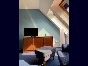 ein Wohnzimmer mit einem TV, einem Stuhl und einem Stuhl in der Unterkunft Willkommen-Glückstadt in Glückstadt