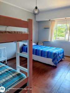 een slaapkamer met twee stapelbedden en een raam bij Amanece en la playa 2 in Santa Teresita