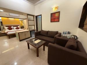 a living room with a couch and a bed at Hotel Beach Garden in Mumbai