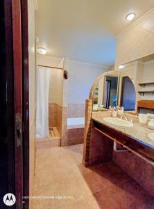 een badkamer met een wastafel en een grote spiegel bij Amanece en la playa 2 in Santa Teresita