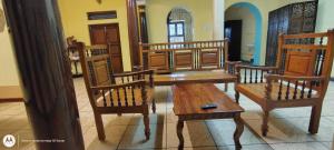 a wooden table and chairs in a room at Elite Heritage Stay in Puducherry