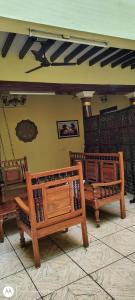 two wooden benches sitting in a room at Elite Heritage Stay in Puducherry