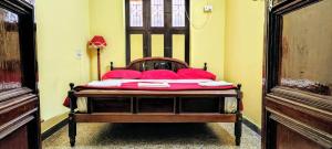 a bedroom with a bed with red pillows on it at Elite Heritage Stay in Puducherry