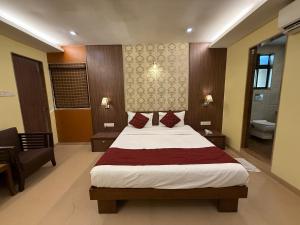 a bedroom with a large bed and a bathroom at Hotel Beach Garden in Mumbai