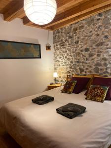 a bedroom with a large bed with a stone wall at La Roche Meane in Villar-dʼArène