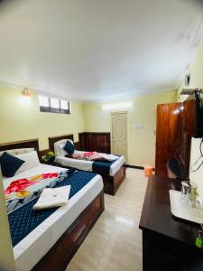 une chambre d'hôtel avec deux lits et un bureau dans l'établissement budget stay-mystique inn, à Ooty