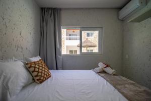 a bedroom with a large white bed with a window at Apartamentos Curimã in Passo de Camarajibe +48 photos